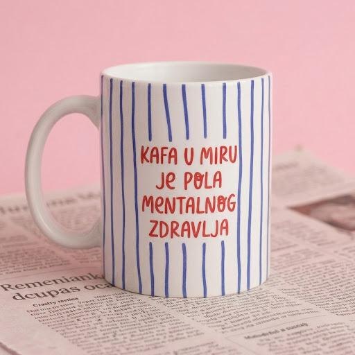 Prugasta šoljica sa natpisom Kafa u miru je pola mentalnog zdravlja